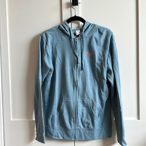 Light blue zip up jacket. Text: “See you in Manzanita”